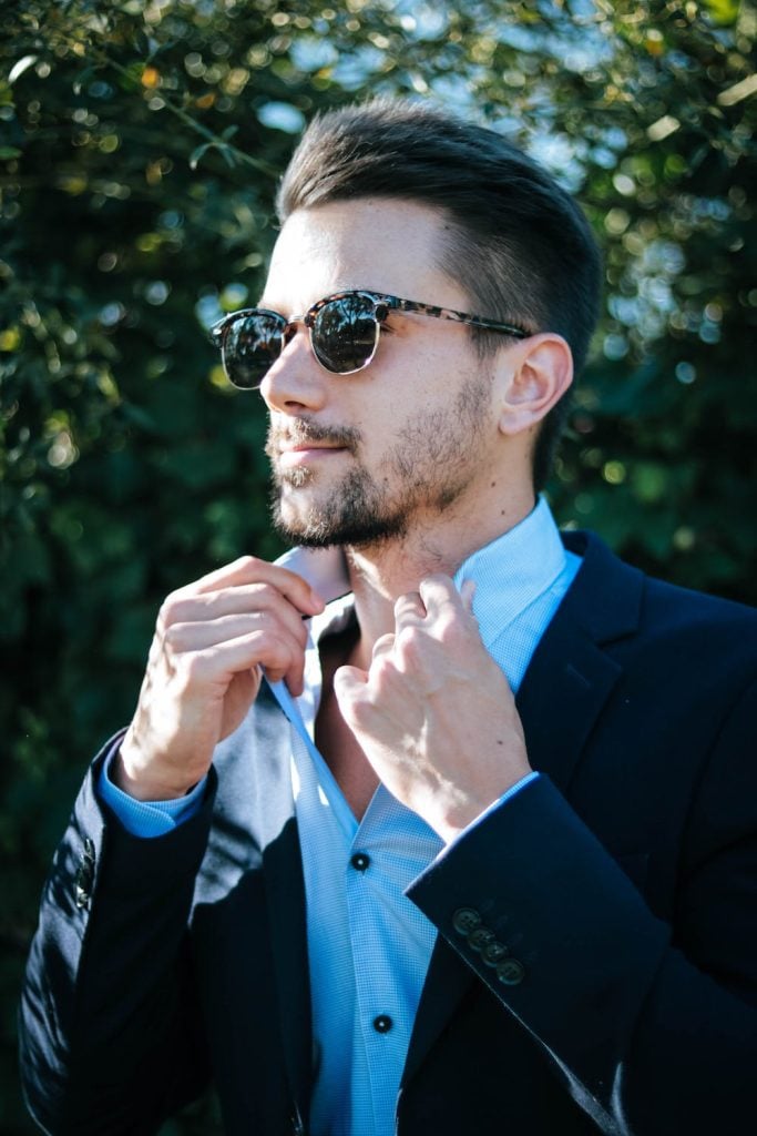 Cool guy in sunglasses wearing a suit looking off to the side.