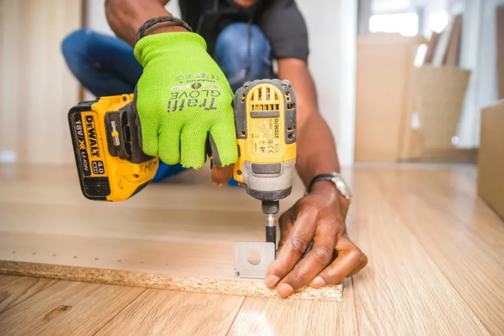 Man drilling into a floorboard