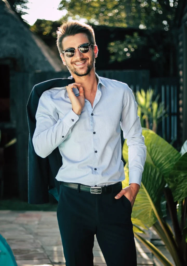 Man in a nice suit and sunglasses smiling to the camera